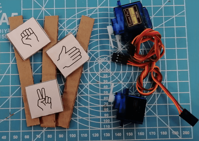 Schilder auf Pappe mit den Symbolen für Stein-Schere-Papier